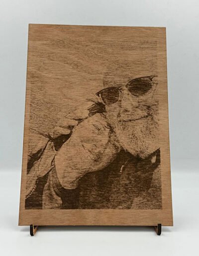 Laser-engraved wooden plaque with a portrait of two people smiling.