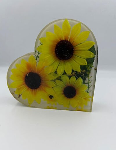 Heart-shaped resin bookend with preserved yellow flowers inside.